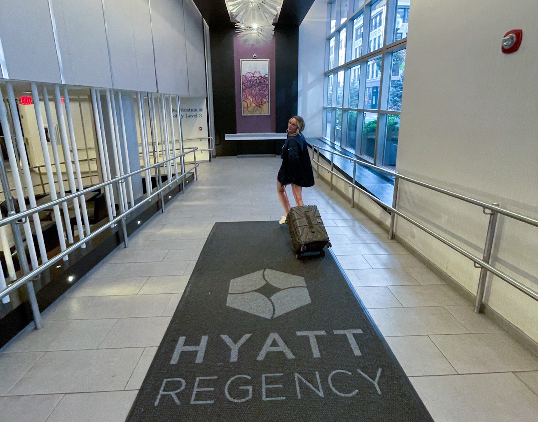 Entering Hyatt hotel with suitcase
